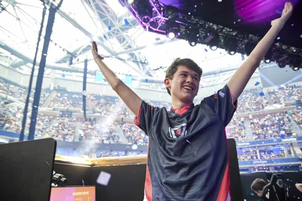 Bugha raises his arms up to the crowd in celebration after taking a win during the Fortnite Championships in 2019