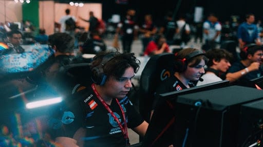 Pro Fortnite player aqua playing on a computer in a crowded area