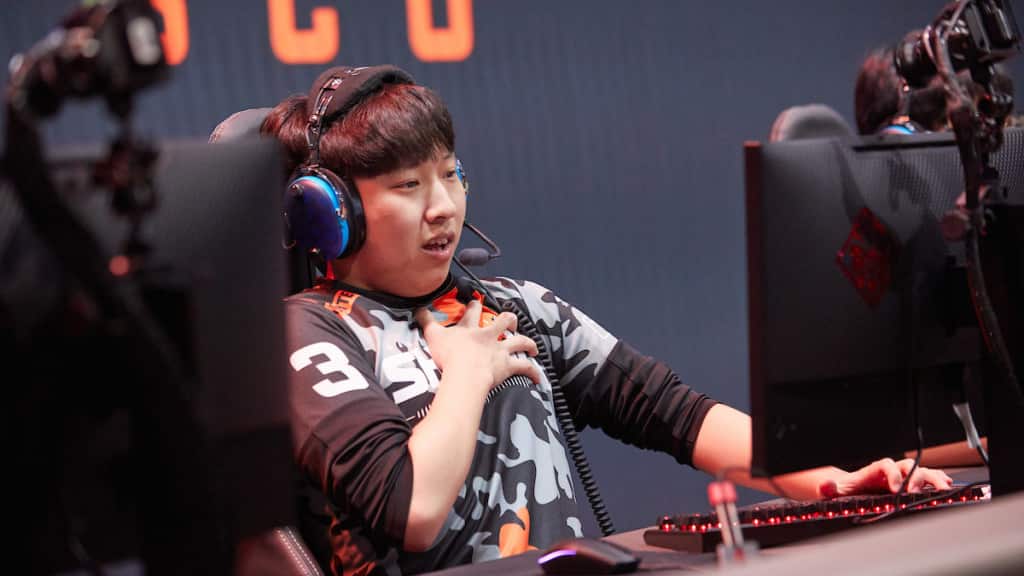 Architect gasps, leaning back in his chair with his hand over his heart during a difficult moment in a game of Overwatch