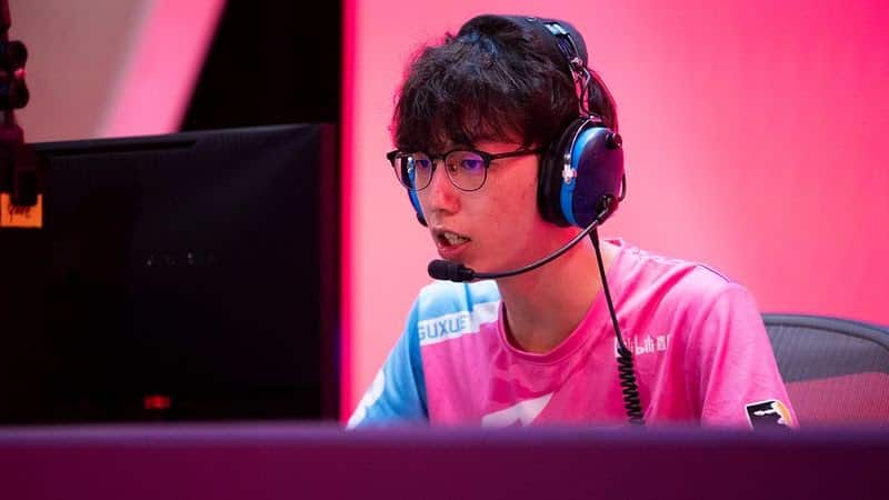 Xu "guxue" Qiulin sits behind the monitor, with headset on, playing a game of Overwatch