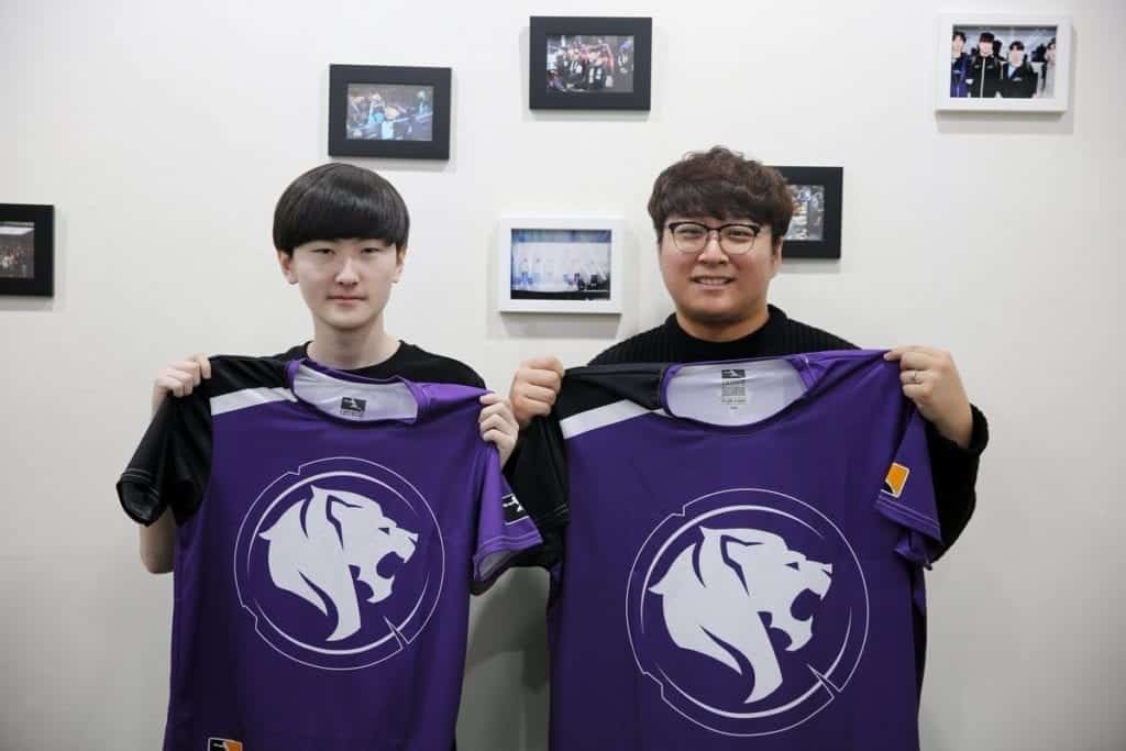 Gui-un "Decay" Jang holding a Los Angeles Gladiators jersey up next to another Overwatch League player