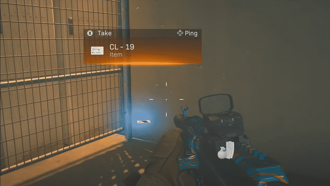 A first person view of a player in Call of Duty Warzone holding a rifle and looking at a blue keycard in Stadium