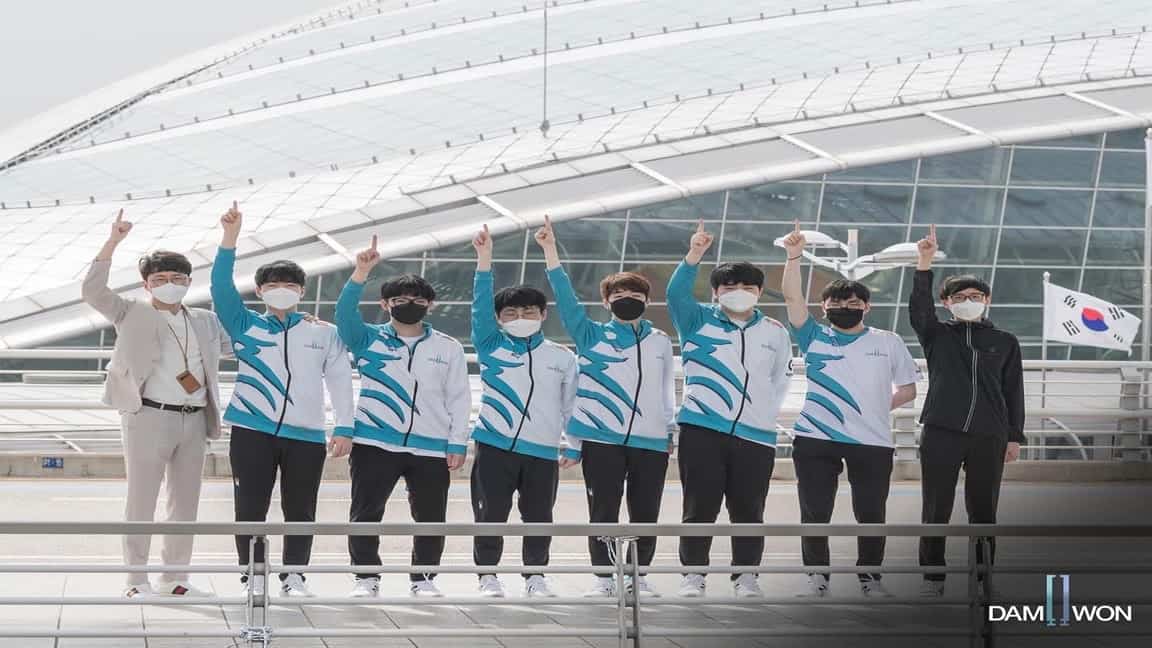 The 2020 Damwon Gaming team stands together at an airport and waves together