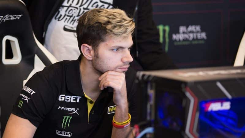 Ilya “Lil” Ilyuk on stage at an event looking intently at a computer screen