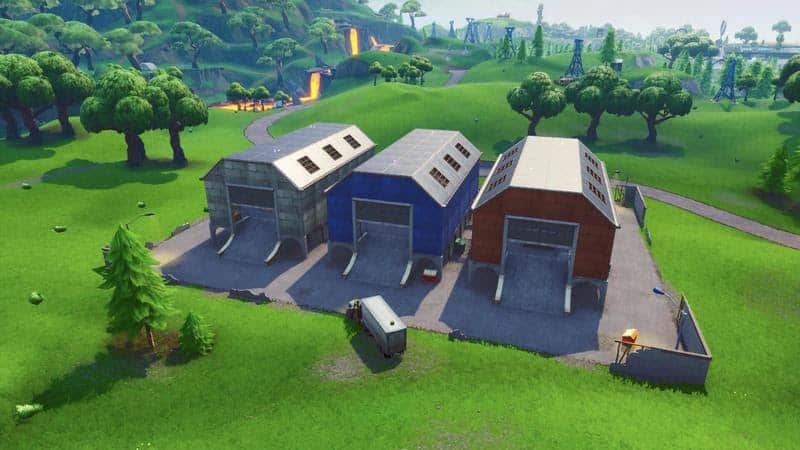 The Dusty Depot area in Fortntie, three long barns in an open field with some trees