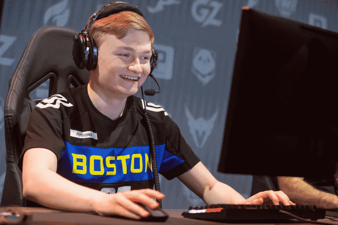 Overwatch player Cameron "Fusions" Bosworth smiling at a PC wearing a Boston Uprisng jersey