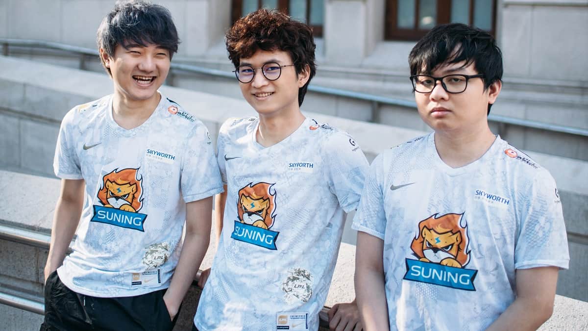 Suning's LoL players Swordart, Huanfeng and SofM pose together outside in their jerseys