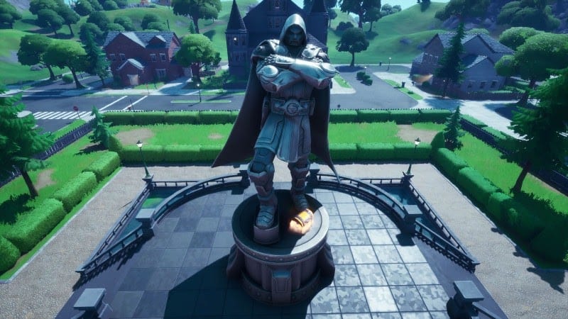The in-game location, Doom's Domain, featuring the imposing stone statue of Dr. Doom outside of a large manor