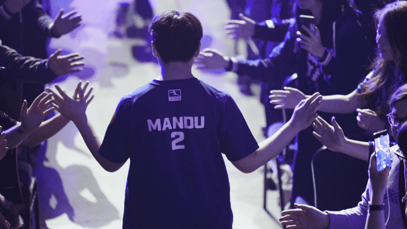 Pro Overwatch League player Chan-hee "Mandu" Kim walks down an aisle high fiving excited fans with the name on his NYXL jersey visible