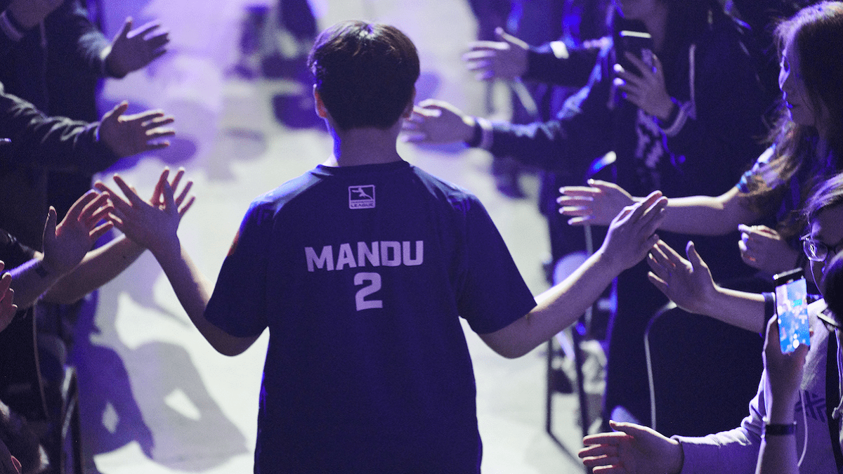 Pro Overwatch League player Chan-hee "Mandu" Kim walks down an aisle high fiving excited fans with the name on his NYXL jersey visible