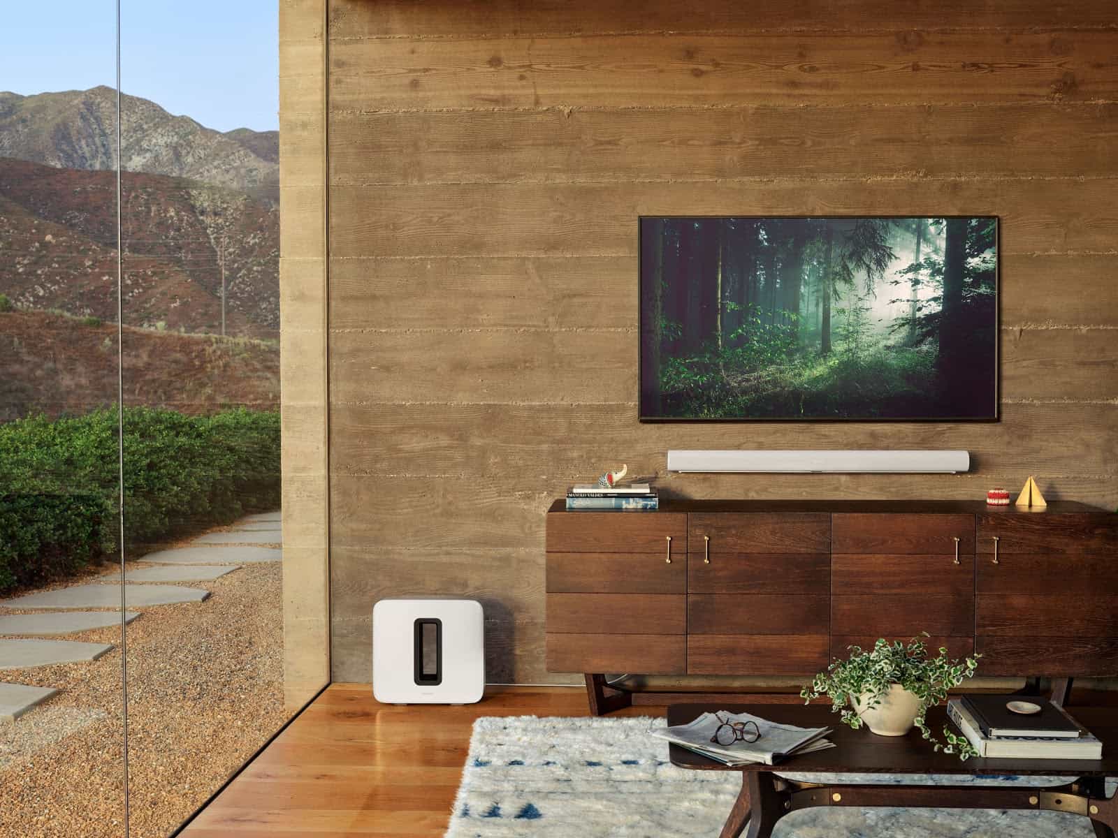 A living room setup is shown with a TV, coffee table and a Sonos Arc soundbar speaker 