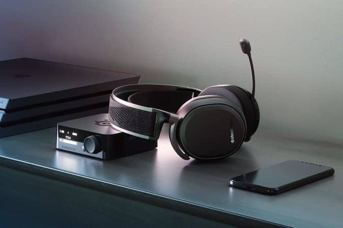 A photo of the SteelSeries Arctis 7 Pro Wireless gaming headset sitting on an entertainments center along with some other pieces of tech