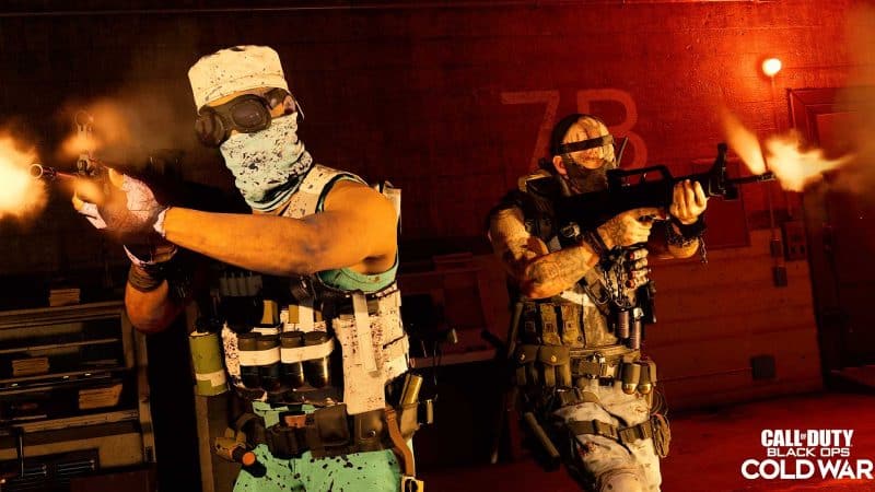 Two soldiers in militia like gear shoot their rifles in a military facility lit with red lights and the words "Call of Duty Black Ops Cold War" in the bottom left corner