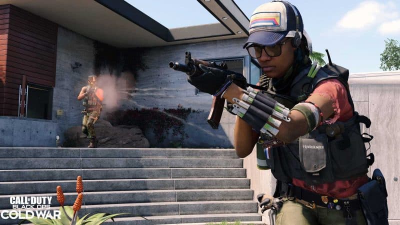The new Operator, Zenya, walks through a battle zone in aviators and a baseball cap, she holds her gun at the ready