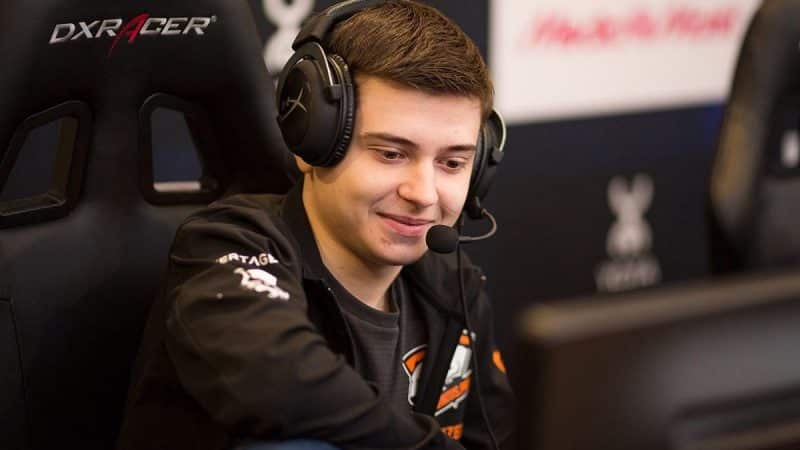 Pro Dota 2 player Roman "RAMZES666" Kushnarev looks down with a smile on his face and a headset on his head