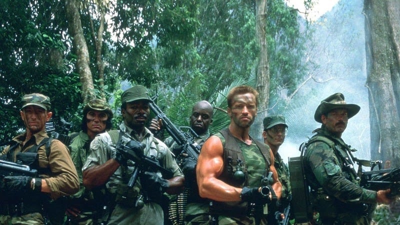 Arnold Schwarzenegger appears alongside other soldiers deep in the jungle in a still from the movie Predator