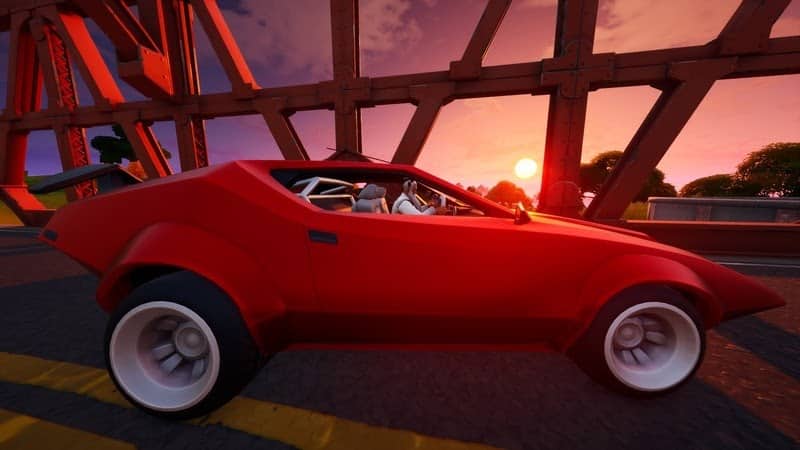 A red car from Fortnite is shown on a bridge with a sunset far in the distance