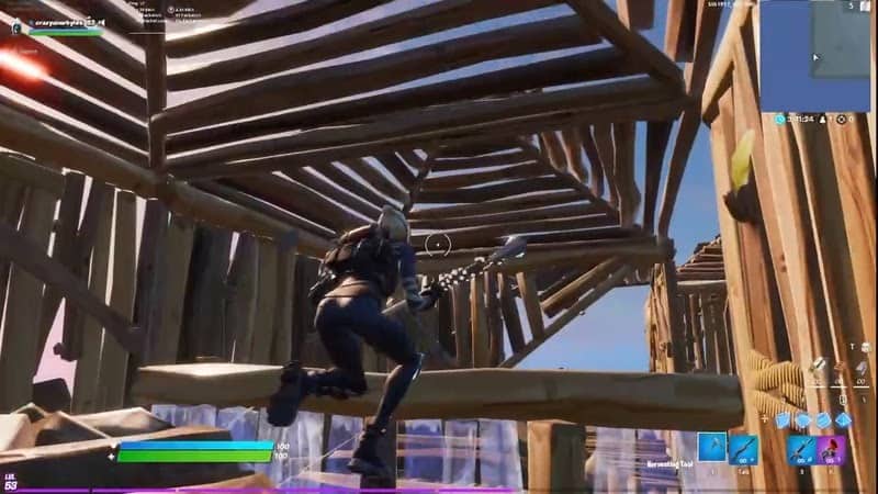 A screenshot from a player playing Fortnite, depicting their character on a player-built wooden structure showing off the tarping mechanic