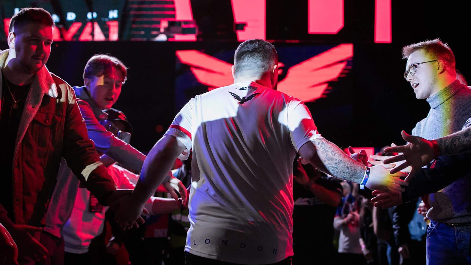 Members of the London Royal Ravens walk off stage high-fiving fans after a game