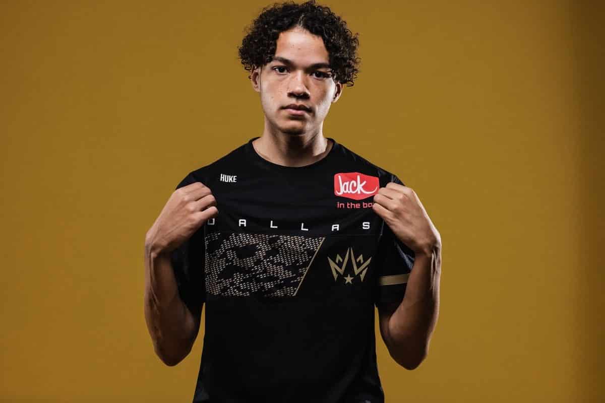 Cuyler “Huke” Garland holds out the front of his Dallas Empire jersesy, showing off the team logo as he faces the camera