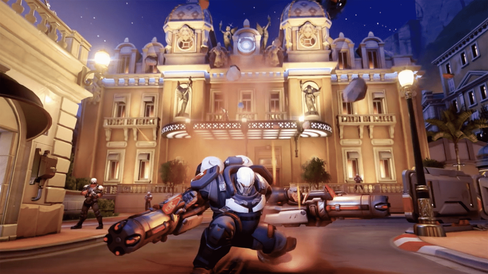 A screenshot from Overwatch with an armored villain character posing menacingly in front of a lit-up building