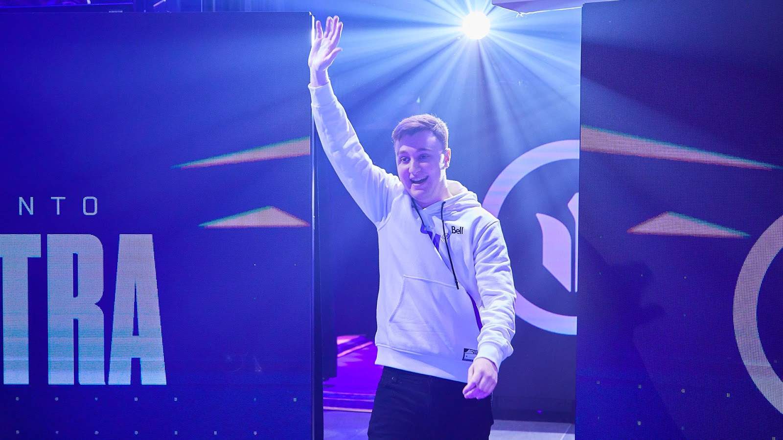 Professional Call of Duty player from Toronto Ultra Cameron "Cammy" McKilligan walks out on stage with his hand up in the air and a bright purple light behind him.
