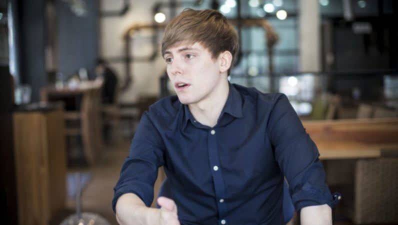 LoL analyst Nick "LS" De Cesare leans on his arm in a cafe while talking to someone