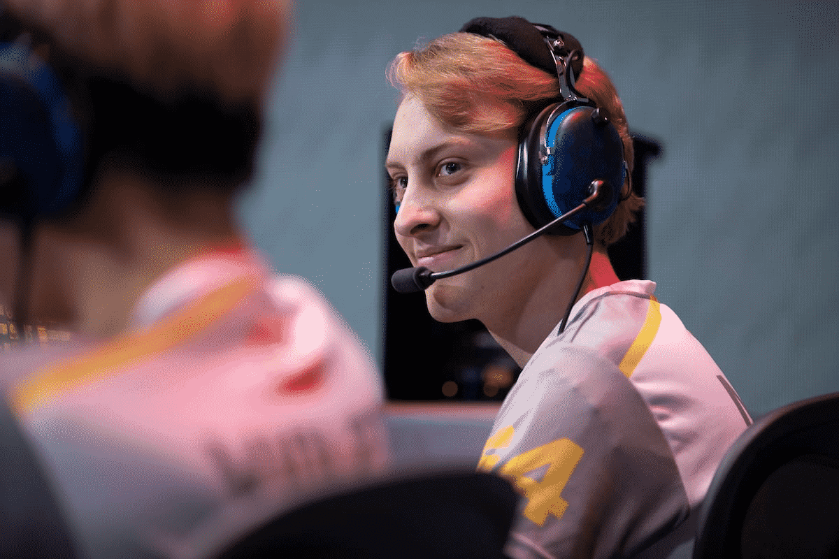 Pro Overwatch player Grant “Moth” Espe sits on the Overwatch League stage and smiles at a teammate to his left.