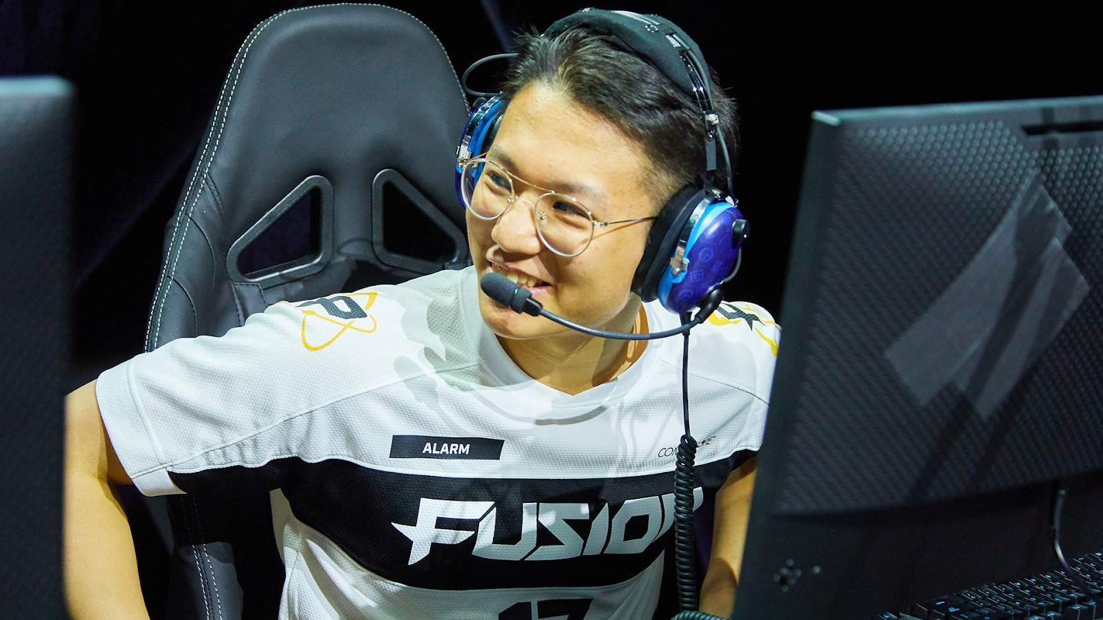 Pro Overwatch player Kyung-bo "Alarm" Kim smiles and beings to stand up after an OWL win.