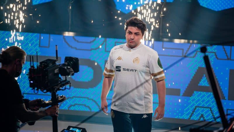 MAD Lions' İrfan “Armut” Berk stands confidently in front of a camera with spark flying behind him.