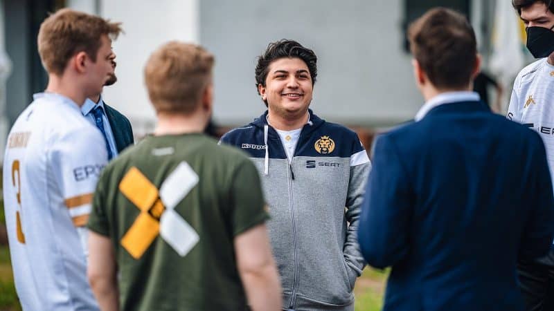 MAD Lions' İrfan Berk "Armut" Tükek stands in a circle of people and smiles joyfully.