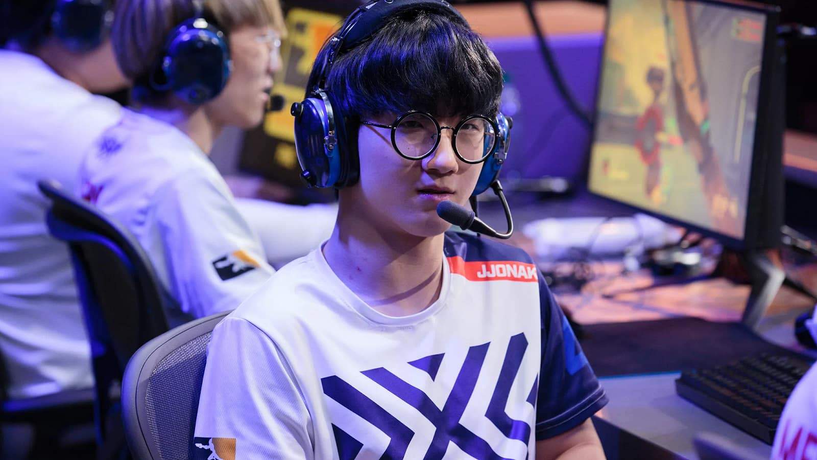Overwatch player Sung-hyeon "JJoNak" Bang looks away from his PC on stage with an NYXL jersey on.