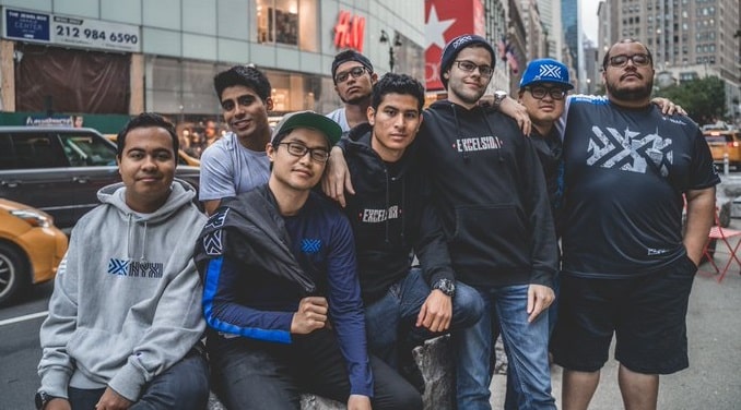The 2021 NY Excelsior Overwatch League team poses in casual clothing near a busy city street.