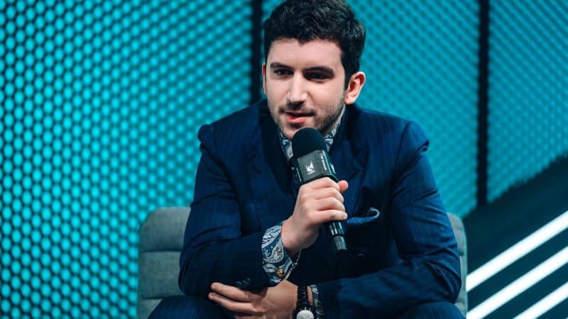 Fnatic coach Jakob "YamatoCannon" Mebdi talks into a microphone during an LEC interview.