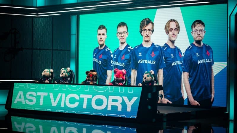 A shot of the LEC stage with the words "AST Victory" on one large monitor with another showing the players of the Astralis LoL roster.