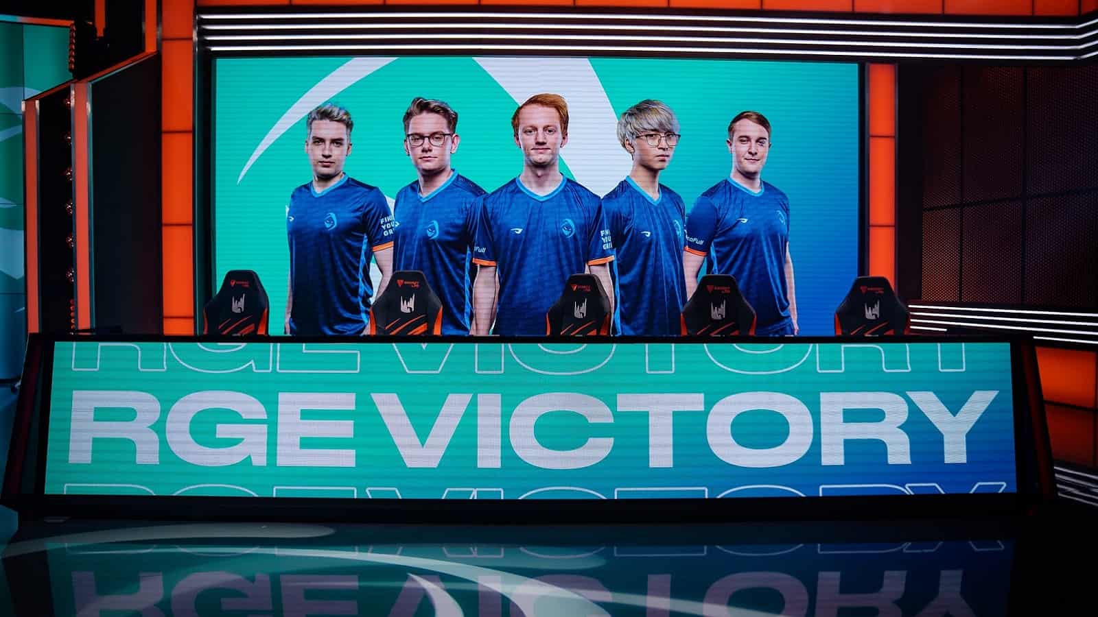 A shot of the LEC stage with the words "RGE Victory" on one large monitor with another showing the players of the Rogue LoL roster.