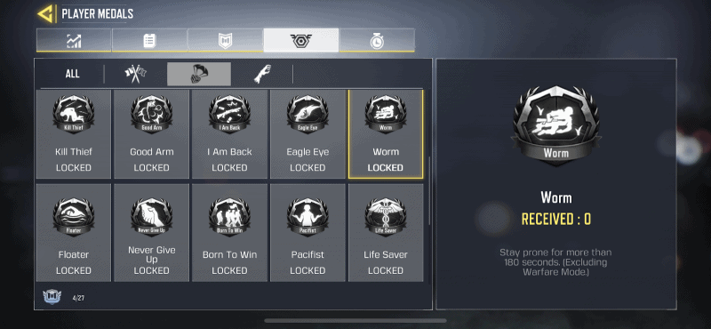 The player medals screen in Call of Duty Mobile showing the Worm Medal, a small black shield with a white silhouette of a man lying prone inside it