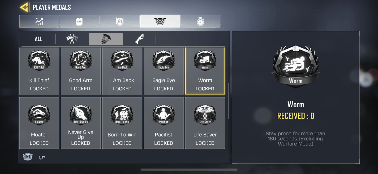 The player medals screen in Call of Duty Mobile showing the Worm Medal, a small black shield with a white silhouette of a man lying prone inside it 