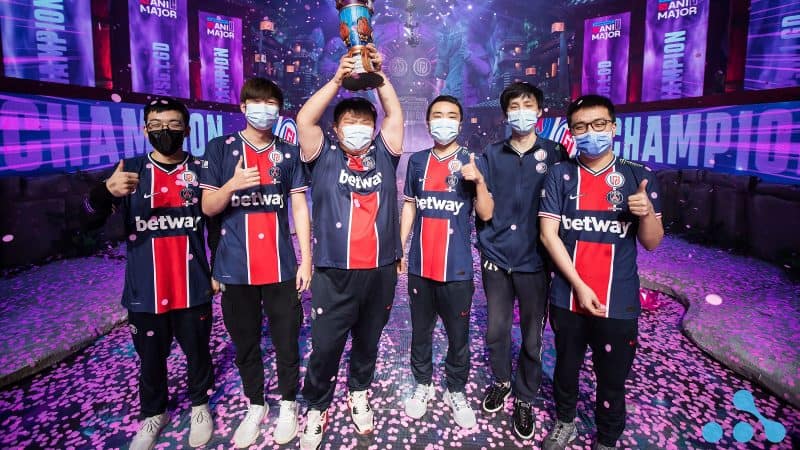The roster for LGD hold aloft their trophy together on stage after winning the WePlay Esports AniMajor in Kyiv