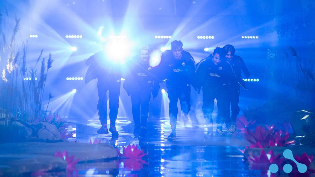 The roster for Team Spirit dash onto the stage with their arms extended out behind them like the anime character, Naruto, ahead of their series against Vici Gaming