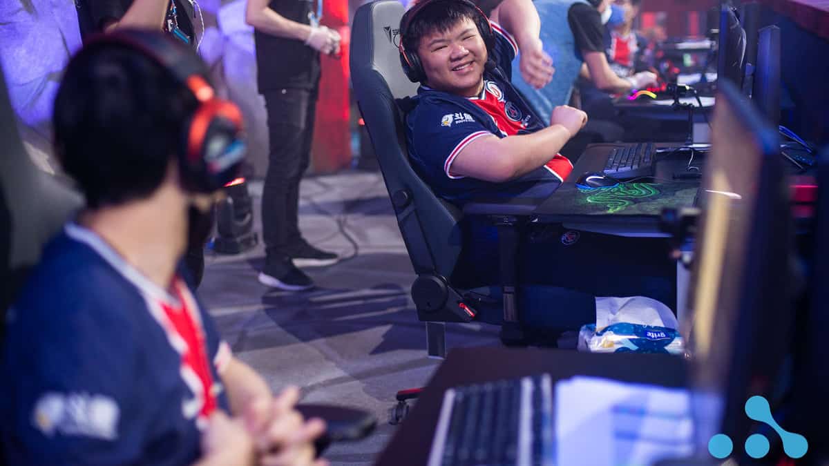 Zhao "XinQ" Zixing laughs with team mates between games on stage at the WePlay AniMajor