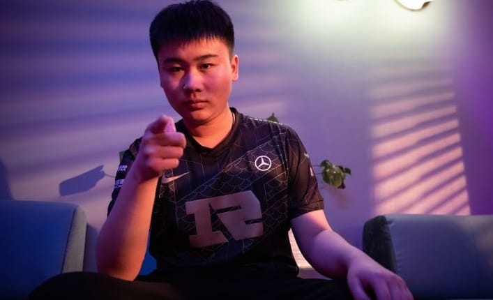 RNG's 2021 jungler Yan “Wei” Yang-Wei sits on a couch and points intimidatingly at the camera.