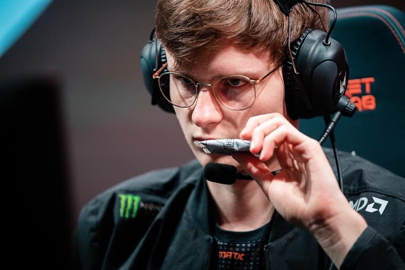 Pro LoL player Elias “Upset” Lipp looks seriously at a monitor and adjusts his headset.