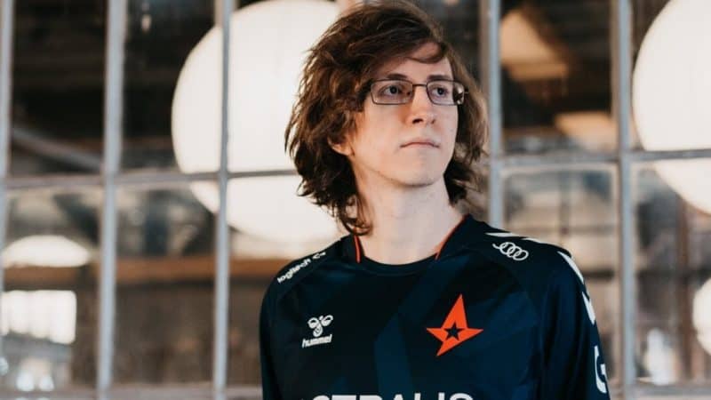 Pro LoL player Felix “MagiFelix” Boström stands with an Astralis jersey on with a wall of windows behind him.