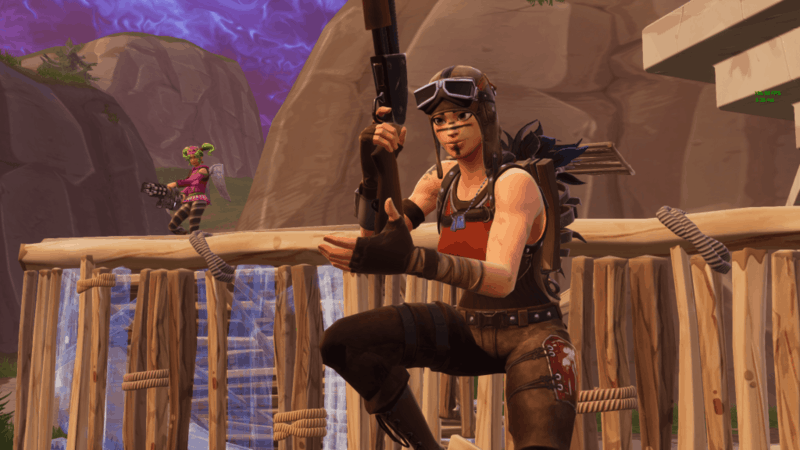 A female Renegade Raider Fortnite character holds a gun on a player made structure.