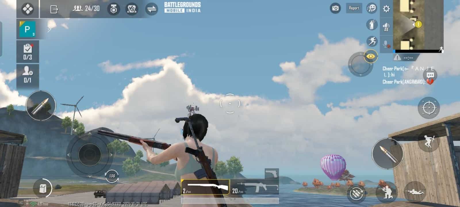 A female character from Battlegrounds Mobile India walks near a shed under a blue sky holding a shotgun.