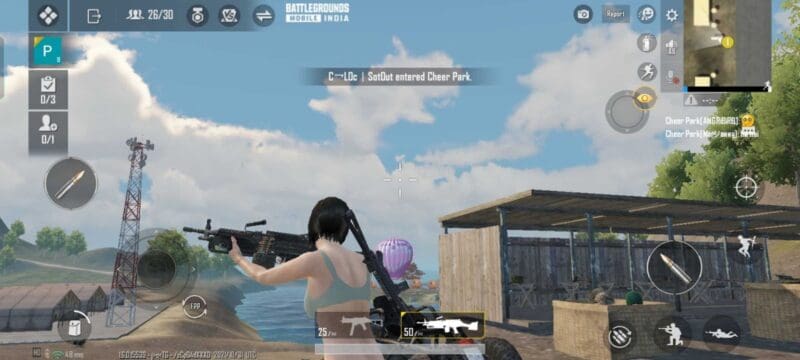 A female character from Battlegrounds Mobile India walks near a shed under a blue sky holding a light machine gun.