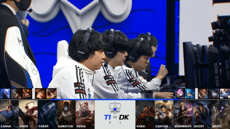 A screenshot from the 2021 World Championship Main Event Semifinals broadcast, showing the Game Two champion drafts between DAMWON KIA and T1 with a shot of the DWG KIA LoL roster on stage above.
