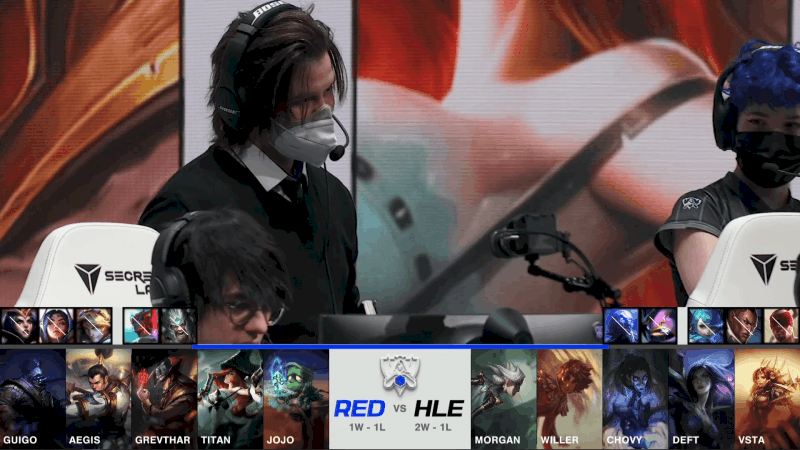 A screenshot from the 2021 World Championship Play-ins broadcast, showing the drafts between RED Canids and Hanwha Life Esports with a shot of coach Coelho on stage in the middle.