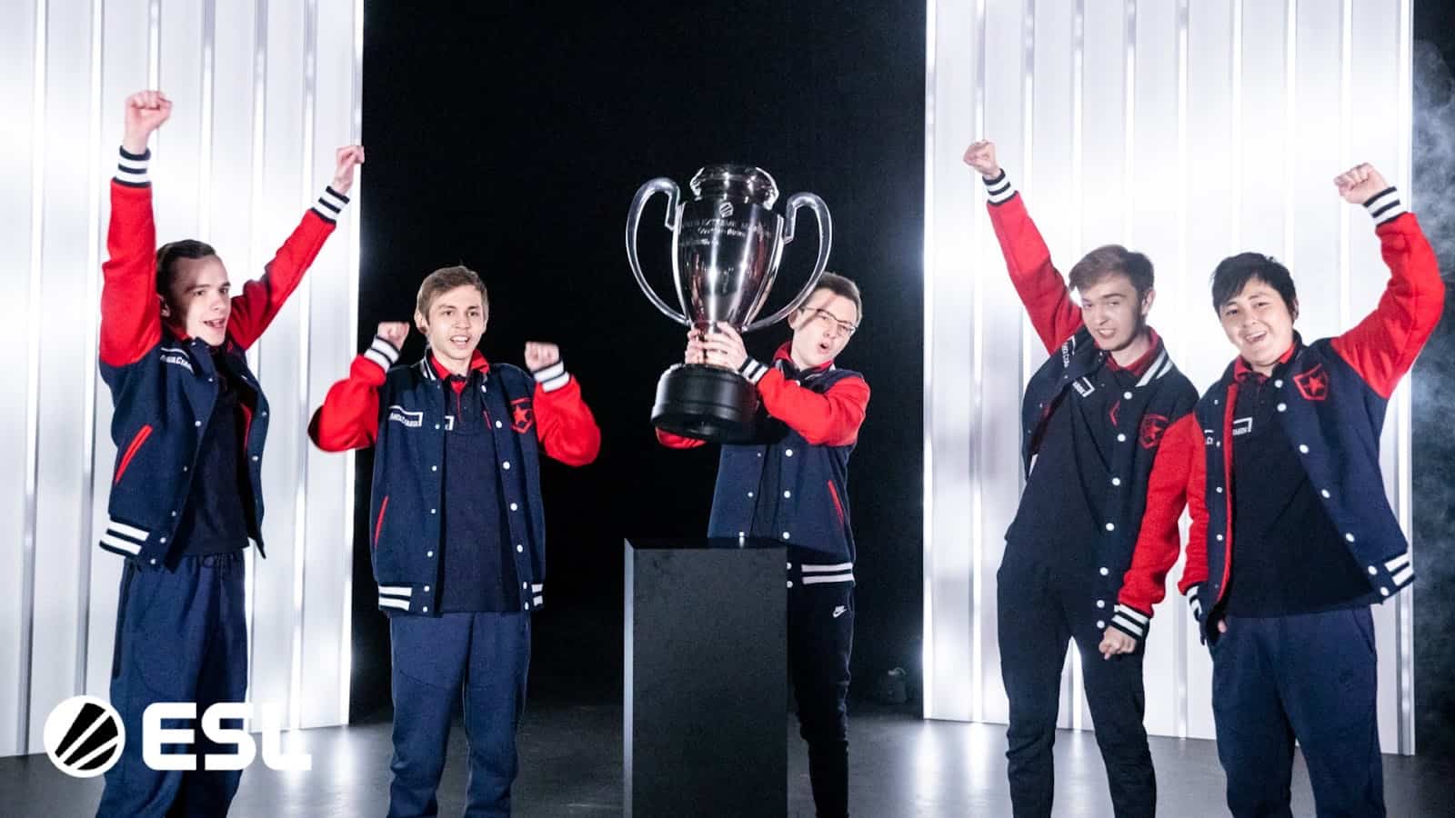 The Gambit CS:GO squad celebrates on stage and lifts a trophy after winning the BLAST Premier Spring Finals.